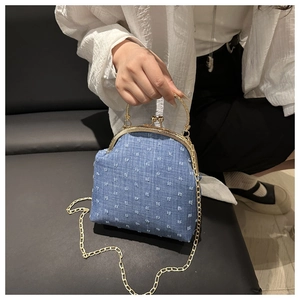 Close-up of light blue denim shell bag with metallic gold clasp and chain strap