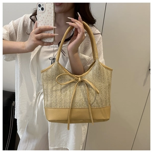 Mirror selfie showing the scale and style of the bow straw shoulder bag for women