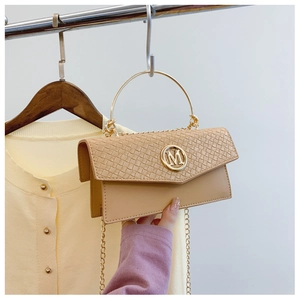 Detail of light khaki handbag featuring woven texture flap and golden M logo detail