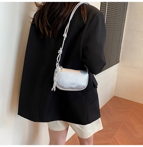 Vue détaillée d'un sac bandoulière argenté en forme de croissant avec texture litchi