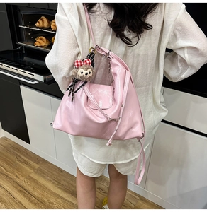 Pink glossy patent leather tote bag with cute plush pendant shown in a lifestyle kitchen