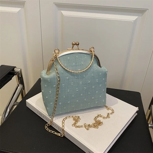 Light blue polka dot crossbody bag with gold handle and retro metal frame clasp