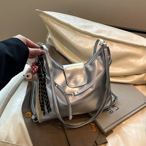 Silver metallic shoulder bag with glossy finish and cute plush charm accessories