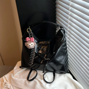Retro black glossy leather backpack with silver hardware and plush bear charm