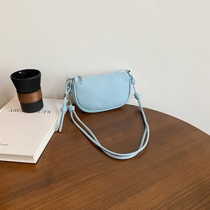 Hellblaue Satteltasche in Halbmondform aus genarbtem Leder mit geknotetem Schultergurt