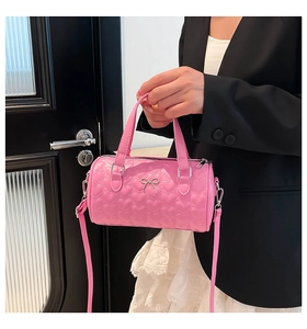 Detail of pink quilted heart pillow bag with silver bow charm and detachable strap