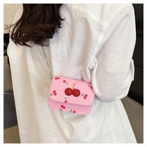 Détail du mini sac en cuir rose avec imprimé cerise et décoration cerise en cristal