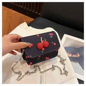 Détail du sac bleu marine à imprimé cerises avec fermoir en cristal 3D et chaîne argent