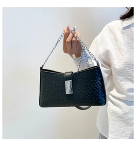 Close-up of black woven leather shoulder bag with silver metal chain and rectangle buckle