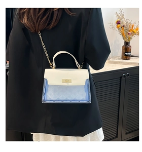 Detail of white PU leather flap with gold twist-lock on blue transparent crossbody bag
