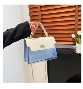 Close-up of contrast color crossbody bag featuring white leather lid and blue PVC base