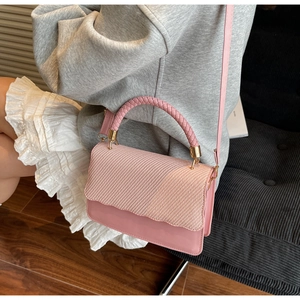 Detailed close-up of pink woven texture on handbag with elegant gold-tone hardware