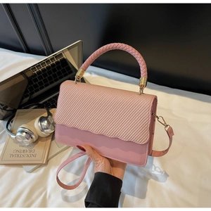 Pink evening shell bag with textured weave flap and braided top handle detail