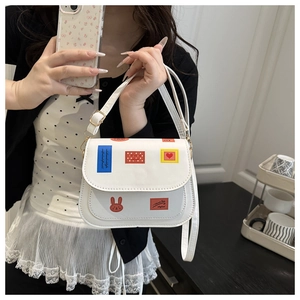 Détail du sac de selle blanc avec écussons colorés et fermoir en métal doré