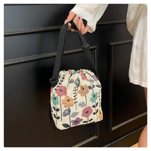 Close-up of beige canvas drawstring bucket bag featuring a vintage floral print design