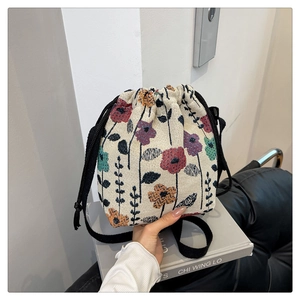 Detail of floral woven fabric and black drawstring on a retro bucket bag for women