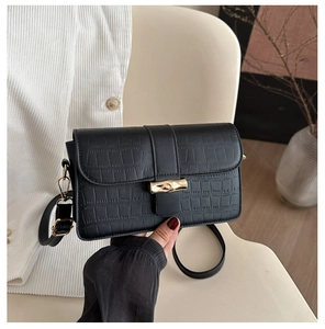 Close-up of black crocodile pattern leather bag with golden bamboo-shaped metal lock