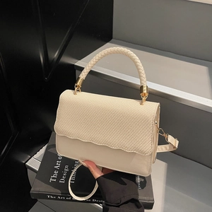 Elegant cream shell bag with woven texture lid and scalloped edges for evening wear