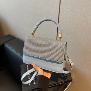 Elegant light blue shell bag with woven texture flap and gold hardware accents
