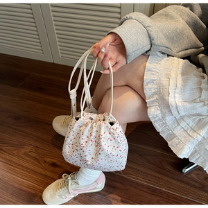 Détail du sac seau en toile florale avec motif fleurs roses et fine bandoulière