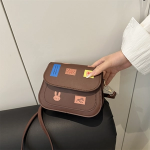 Brown leather saddle bag with cartoon prints and adjustable shoulder strap for women