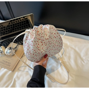 Gros plan du sac à cordon floral avec lanières en cuir et coutures de précision détaillées