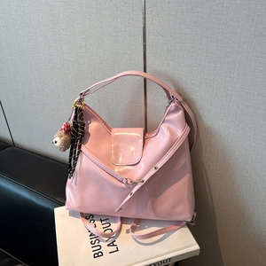 Detailed view of pink faux leather hobo bag with teddy charm and striped ribbon detail