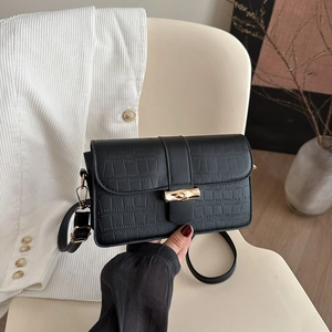 Elegant black crocodile texture crossbody bag with gold bamboo clasp for modern women