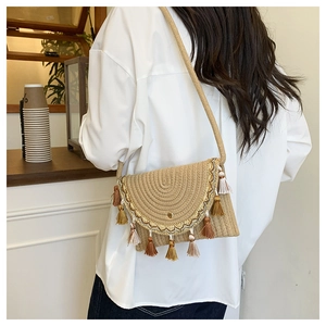 Detail of bohemian woven straw bag with decorative fringe tassels and a spiral texture