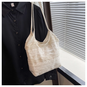 Détail d'un sac cabas en dentelle blanche avec broderies crochetées et motifs ajourés