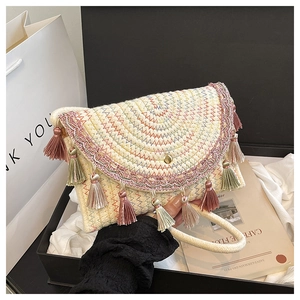 Detail showing bohemian woven clutch with colorful zigzag patterns and tassel charm