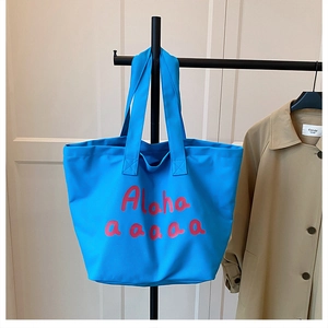 Detailed view of spacious blue canvas tote bag featuring bold pink Aloha lettering print