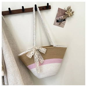 Detail of tricolor woven tote bag with a lace bow and long rope handles for beach vacation