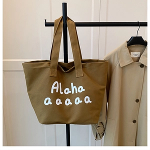 Detail of a khaki canvas tote bag with Alaha lettering and spacious interior