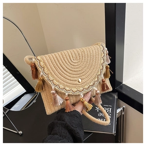 Close-up of bohemian woven straw bag with colorful fringe tassels and embroidery detail