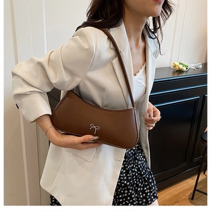 Nahaufnahme der braunen PU-Ledertasche mit einer silbernen Schleife aus Metall