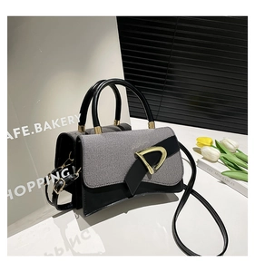Detail of grey textured fabric tote bag with golden D-ring buckle and tulip decor