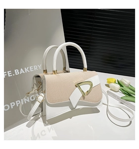 Detail of color-block crossbody bag with beige woven flap and gold D-ring hardware