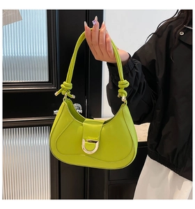 Détail du sac bandoulière vert fluo en daim avec boucle D dorée et finitions de bandoulière