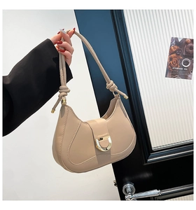 Détail du sac demi-lune kaki clair avec boucle dorée en D et bandoulière à nœud