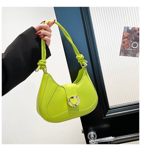 Détail du sac croissant vert fluo avec boucle en D argentée et bandoulière à nœuds