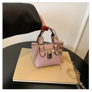 Detailaufnahme der lila Mini-Tasche mit Litschimuster, Herzschloss und Kettenriemen