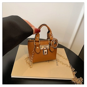 Nahaufnahme der braunen Mini-Tasche aus Leder mit Litschimuster und goldener Kette