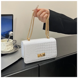Detail of white crocodile pattern shoulder bag with golden chain and metallic lock