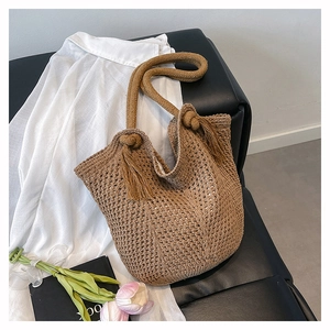 Detailed shot of dark brown hand-woven knit tote bag with thick rope straps and fringe