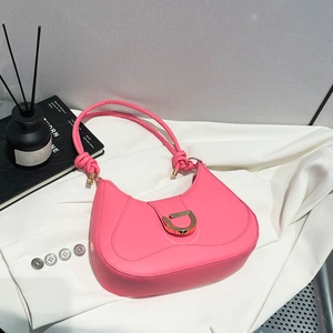 Sac hobo rose en cuir avec boucle D dorée et bandoulière nouée sur fond minimaliste