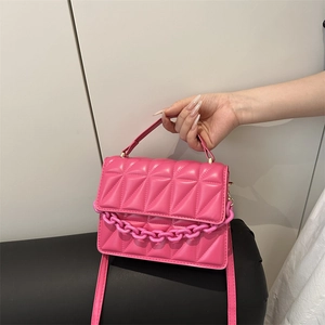 Bright pink quilted crossbody bag with chunky chain handle and dopamine fashion style