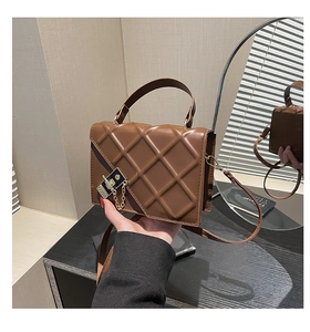 Detail of coffee rhombus quilted bag with gold chain and metal lock closure