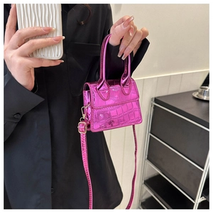 Detail of pink croc-embossed mini handbag with metallic finish and shoulder strap