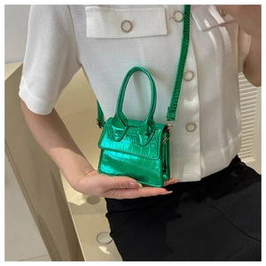 Close-up of vibrant green crocodile-embossed mini handbag with metallic finish